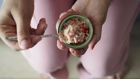 person eating canned tuna