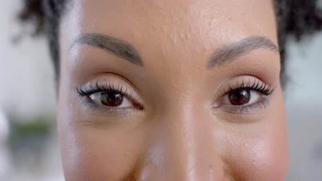 portrait of happy eyes of biracial woman in bathroom with copy space, slow motion