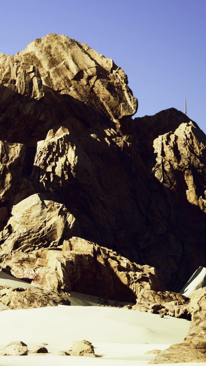 Rock formations with sand under clear blue sky at a natural site