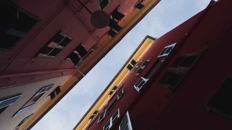 Vista giratória em ângulo baixo de edifícios estreitos e céu em Gênova