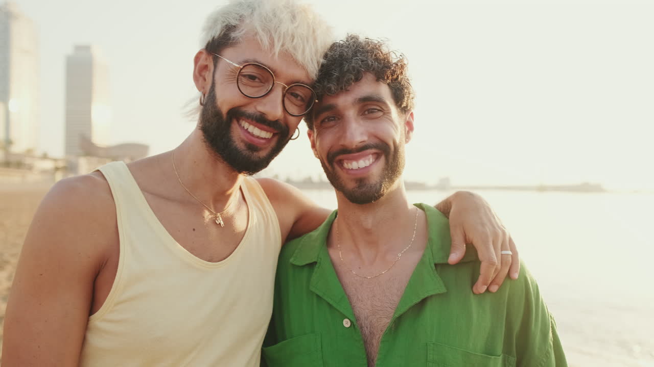 Happy Gay Couple Embracing and Smiling on a Beach at Sunset