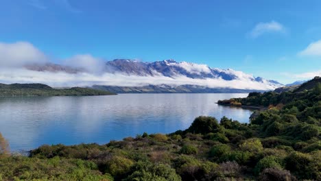 drone captures stunning views of lake wakatipu and surrounding mountains under clear blue skies in glenorchy, new zealand