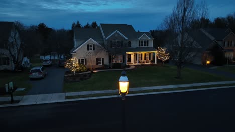 Twilight-descends-on-a-tranquil-suburban-neighborhood,-highlighting-homes-with-festive-lights-under-a-dusky-sky,-captured-by-a-drone-in-the-USA