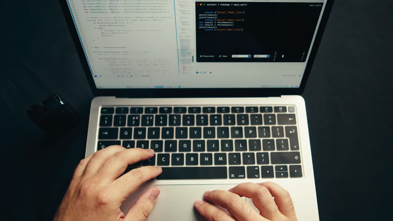 Overhead View of Hands Typing Code on a Laptop