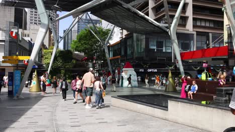 peatones caminando por una concurrida plaza de la ciudad