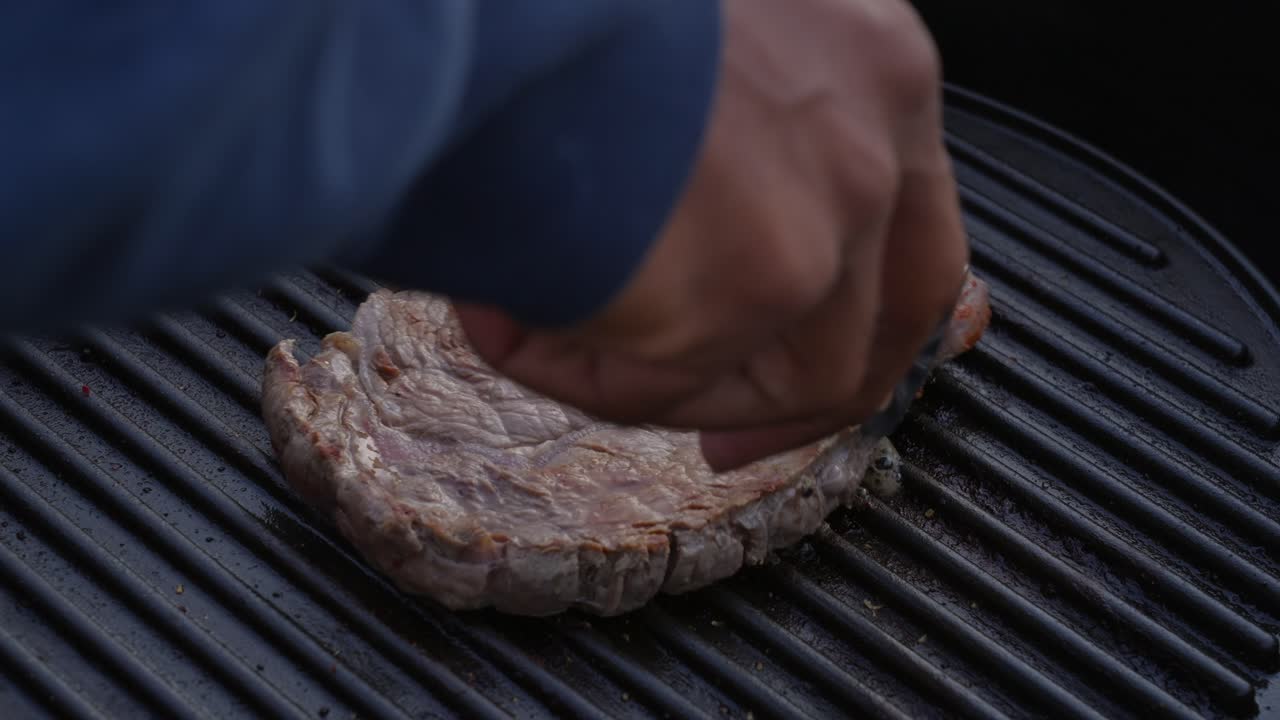 cerca de un jugoso filete de carne de res volteado con pinzas en la parrilla caliente