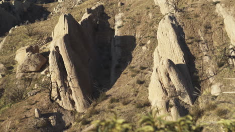 Aerial-close-up-of-dramatic-rock-formations-at-Devil's-Punchbowl,-highlighting-the-sharp-edges-and-rugged-texture-of-the-sandstone