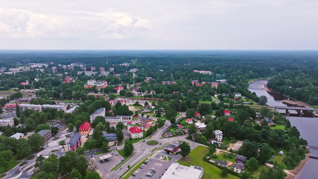 Distant drone shot of Ogre Latvia with yellow train and winding river below