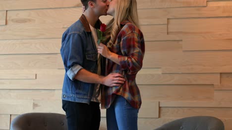 young man giving rose to woman in cafe 4k