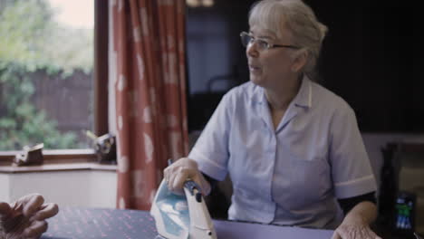 woman ironing clothes indoors