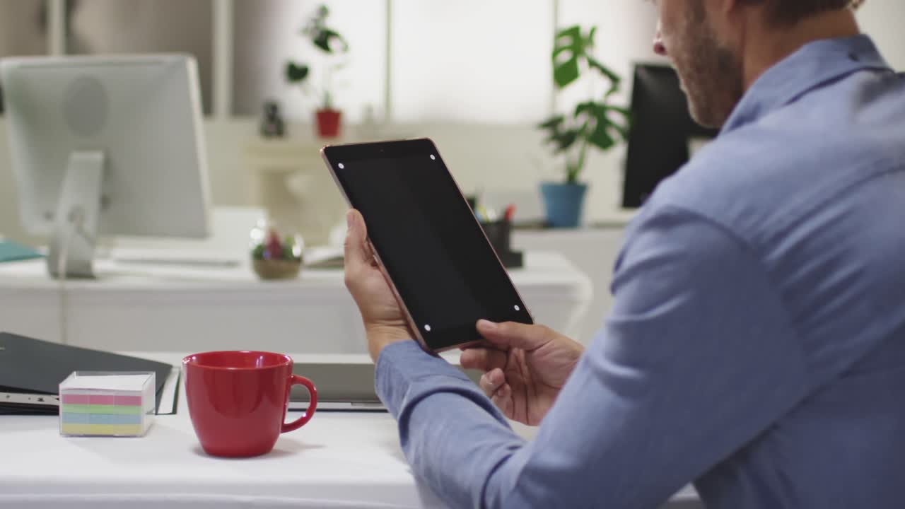 Caucasian businessman having video call meeting using tablet in empty office