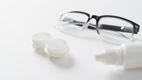 vídeo de gafas, caja de lentes de contacto y solución de lentes sobre fondo blanco con espacio para copiar