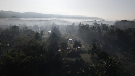 aldea y bosque envueltos por la niebla en la mañana en la isla de sumba, indonesia