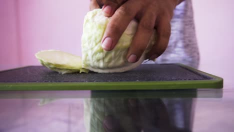 young man cutting cabbage for salad
