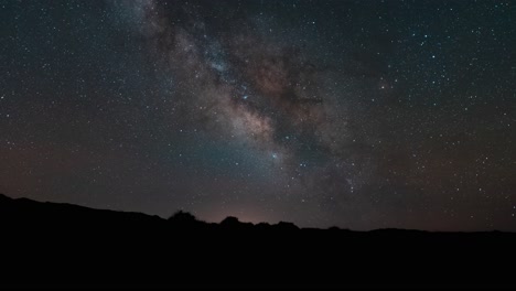 El-Centro-De-La-Galaxia-De-La-Vía-Láctea-Moviéndose-A-Través-Del-Cielo-Sobre-El-Horizonte-Del-Desierto---Lapso-De-Tiempo