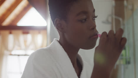 african american attractive woman brushing teeth in bathroom