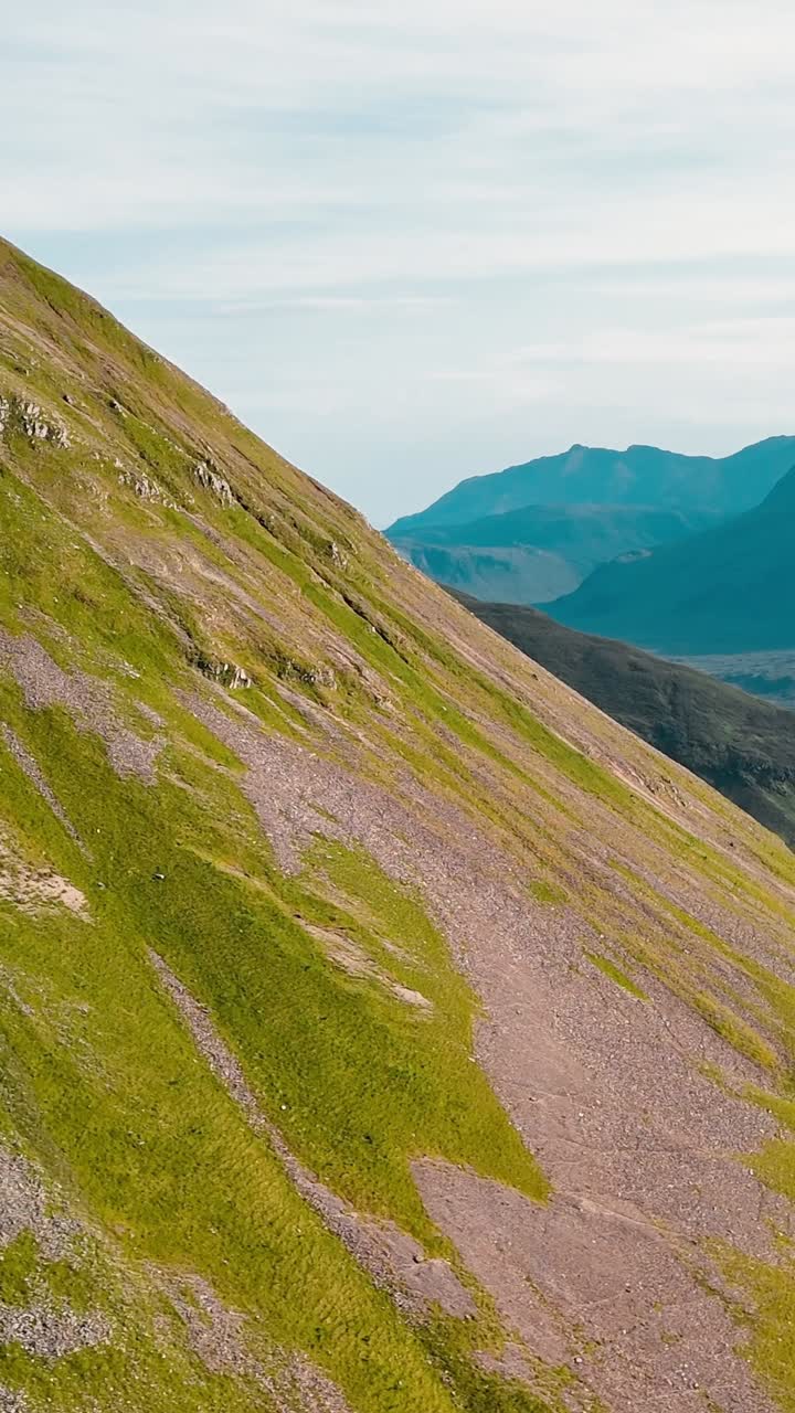 Dolci colline verdi e pendii rocciosi mostrano la bellezza delle Highlands scozzesi