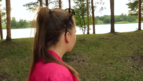 niña caminando en el parque al lado de un lago