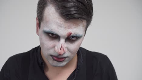 man with scary face paint looking at camera, closeup portrait