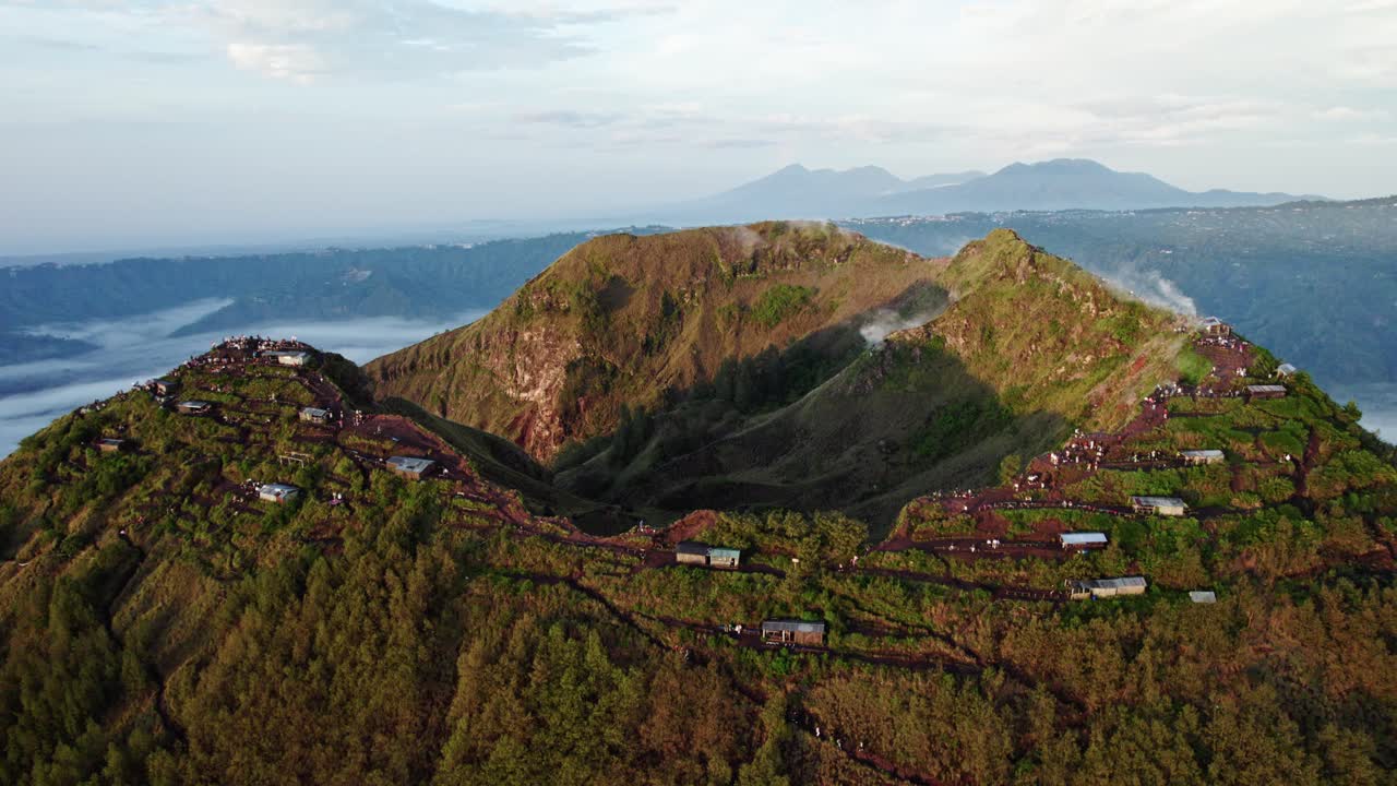 Volcano crater Mount Batur rising aerial at dawn, Bali