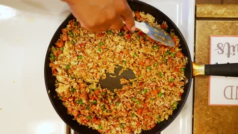 revolviendo el jamón de arroz y las verduras antes de agregar