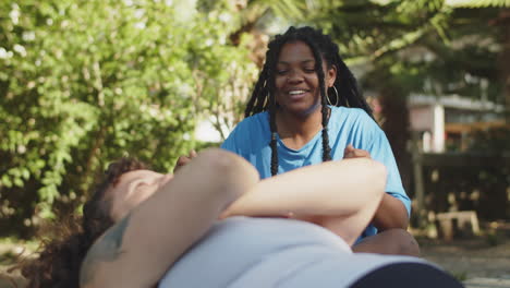 medium shot of cheerful girl supporting friend who doing sit-ups