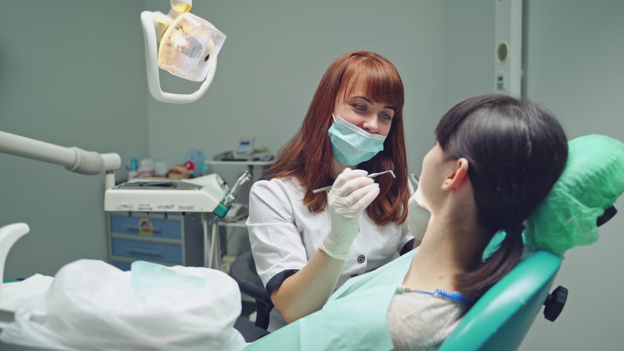 Dental clinic. Woman dentist working at her patients teeth