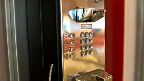 un teléfono de botón. la mano de una mujer levanta el teléfono y marca un número de teléfono
