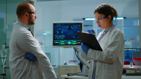 equipo de químicos trabajando con la imagen de escaneo de adn mirando el escritorio