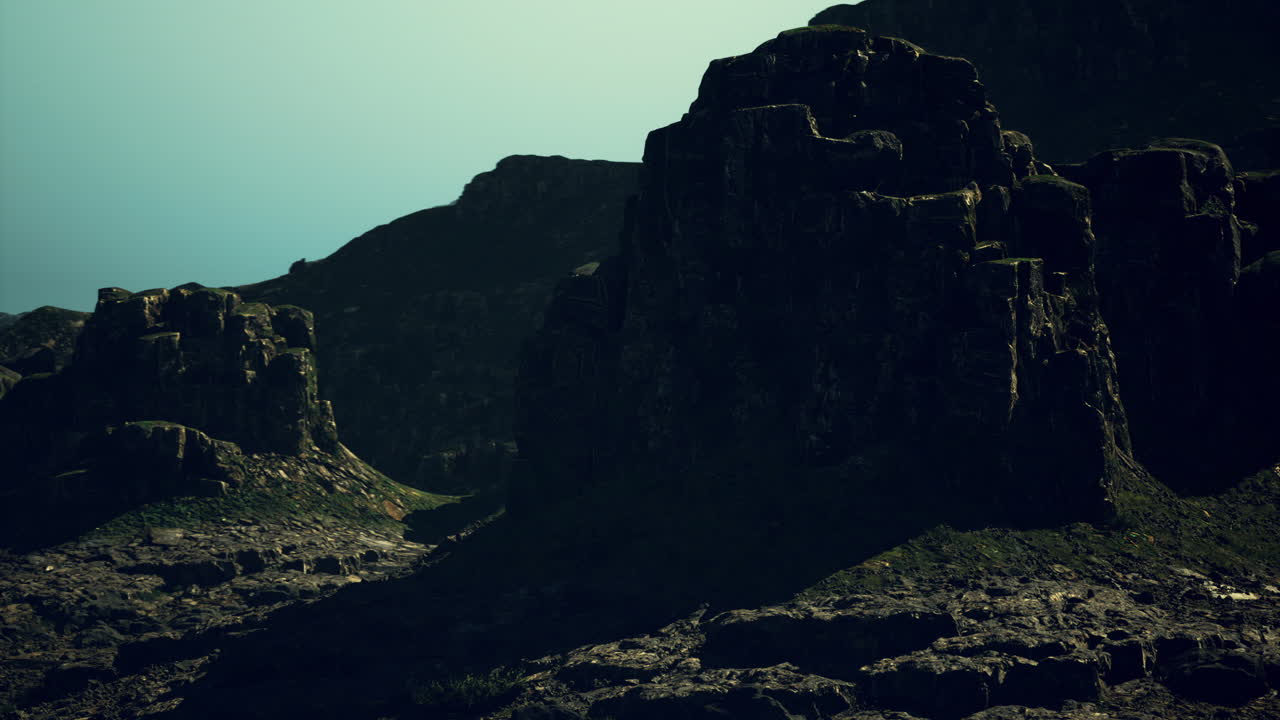 Ancient rock formations cast long shadows at dusk near mountains in nature