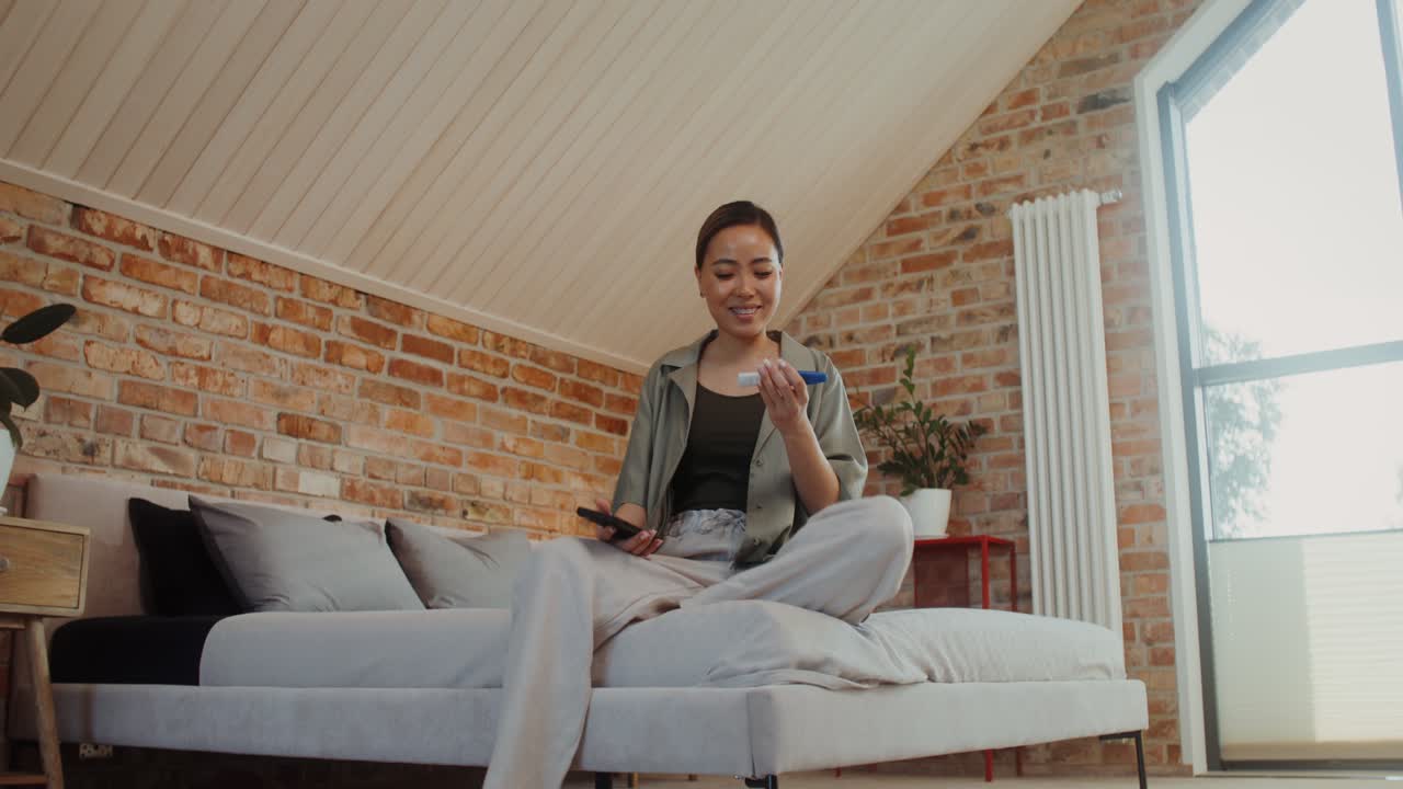 가정에서 스마트폰으로 임신 테스트를 확인하는 여성