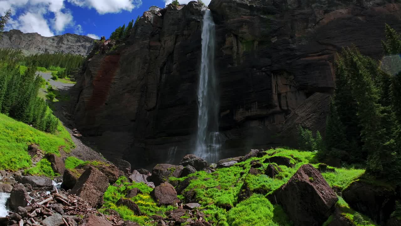 Summer Telluride Box Canyon Bridal Veil Falls Waterfall Colorado Black Bear Pass Road Rocky Mountains 4wd hiking blue sky cliffside valley aerial drone clouds Uncompahgre National Forest backwards pan