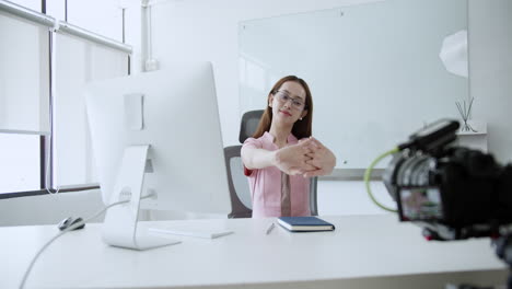 stretching out her arms and hands, a corporate woman is trying to relive the stress she is feeling.
