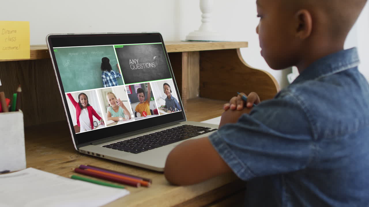 African american boy having a video conference with teacher and classmates on laptop at home