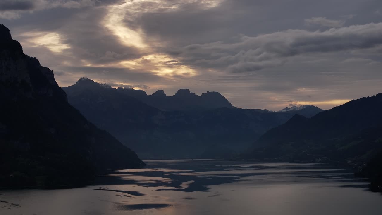 Silhouetted Mountain Ridge On The Lake Walen At Dawn In Switzerland. Aerial Shot