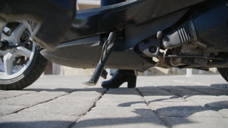 slow motion of woman with black boots in starting position on scooter