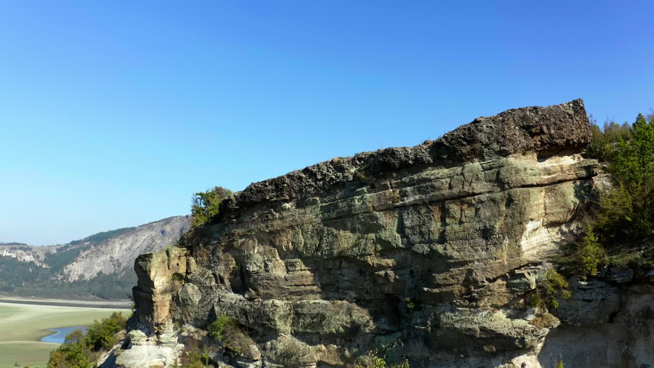 Aerial reveal footage of a stone cliff over the Studen kladenec dam, Rhodope mountain, Monyak peak, in Bulgaria