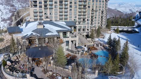 beautiful aerial drone shot of a resort and roads covered with snow over park city, utah, usa in a cold wintry morning