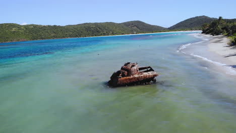 Viejo-Tanque-En-El-Océano-Mientras-Las-Olas-Chocan-En-Un-Hermoso-Entorno-De-Playa