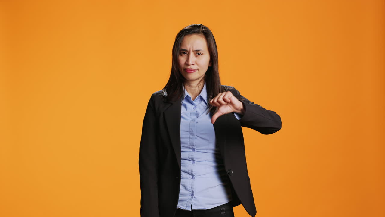 empleado asiático mostrando un signo de disgusto frente a la cámara