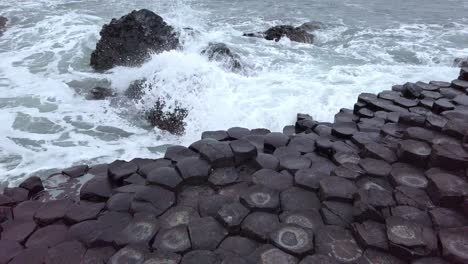 waves crashing over the giants causeway in northern ireland