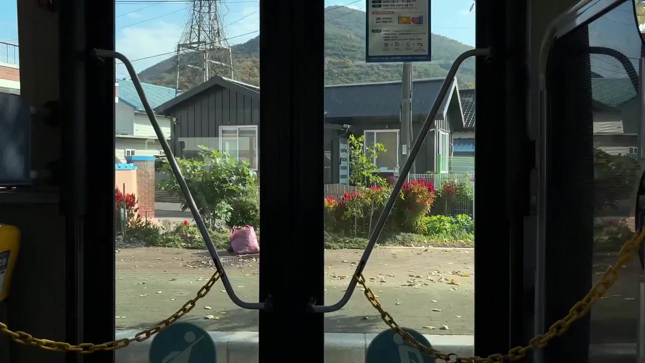 View from inside a bus traveling through the countryside of Gyeongju South Korea showing various buildings and landscapes