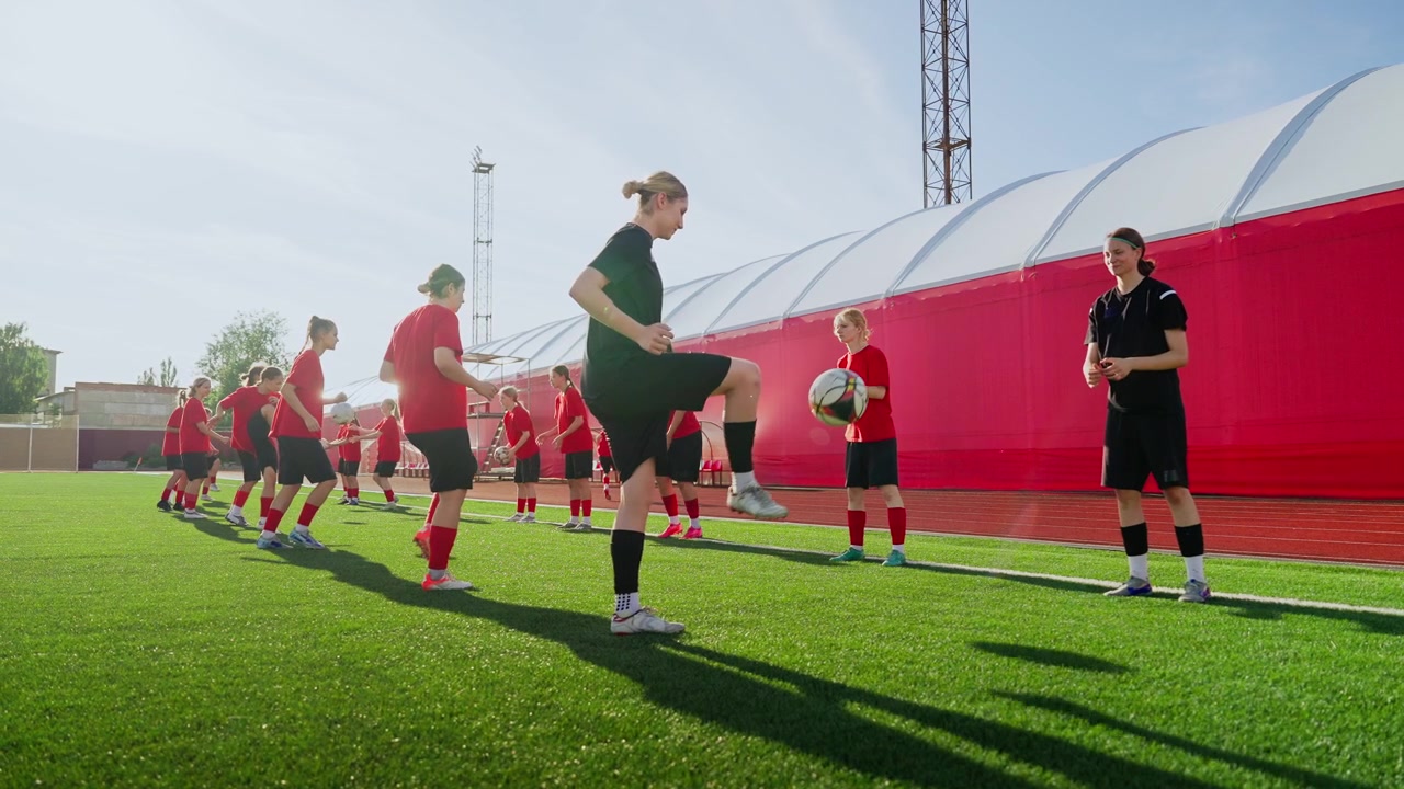 Squadra di calcio femminile che si allena con esercitazioni sul controllo del pallone su un campo all'aperto