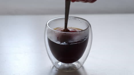 adding one teaspoon of coffee powder into double wall glass and stir to dissolve