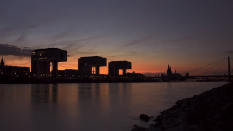 colorful day to night timelapse of colognes crane houses and rhine river in the foreground