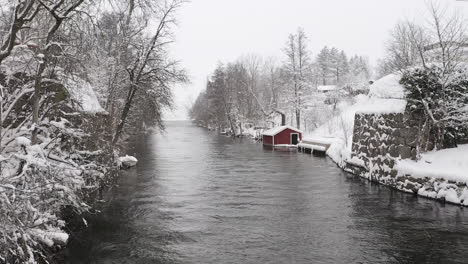 Drone-shot-of-a-small-cabin-by-a-small-stream-river-in-Sweden