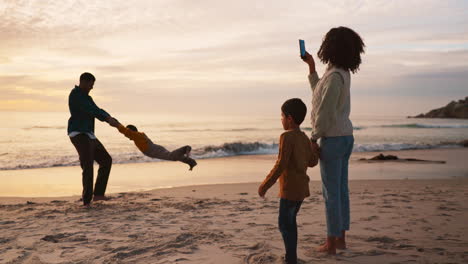 beach, sunset and family taking a picture