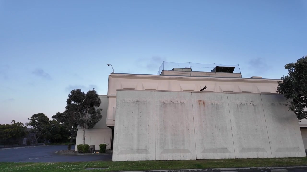 Ampia veduta del tribunale superiore della contea di Alameda, un edificio governativo ufficiale per il sistema giudiziario e legale, mostrato dal parcheggio vuoto durante una sera serena.