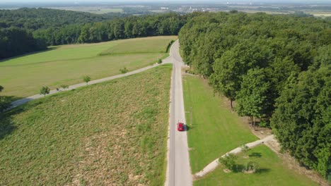 Un-Dron-Rastreando-El-Coche-En-La-Carretera-En-La-Zona-Forestal