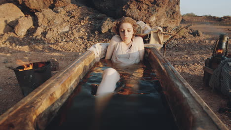 woman lying in dirty bath in post apocalyptic world